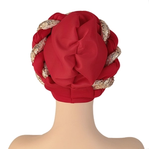 Rear view of red satin turban featuring detailed gold sequin braid wrap design