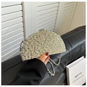 Detail of silver metallic semi-circle clutch bag with hammered texture and chain strap