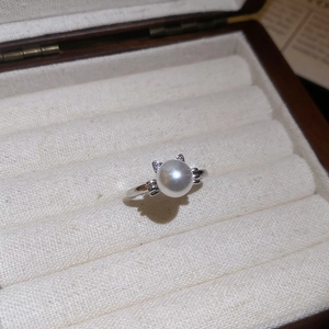 Detailed view of cat-ear pearl ring featuring cubic zirconia and polished silver finish