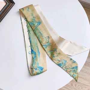 Gros plan d'une écharpe en soie avec paysage chinois traditionnel sur une table blanche