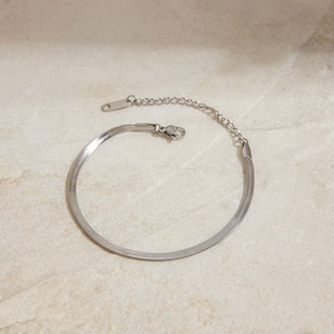 Nahaufnahme eines silbernen flachen Schlangenkette-Armbands mit Karabinerverschluss