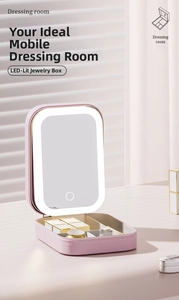 Detail of pink portable cosmetic organizer box with built-in LED light mirror and partitions