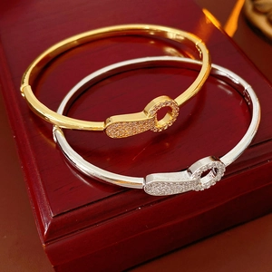 Macro shot of gold and silver plated bangles with crystal keyhole buckles in a gift box