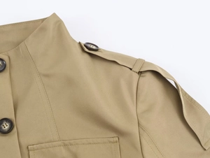 Detail der khakifarbenen Militärjacke mit Stehkragen, Schulterklappen und Steppnähten