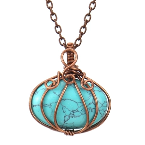 Macro shot of handmade wire-wrapped turquoise pumpkin pendant necklace in bronze finish