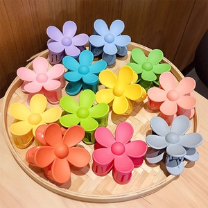 Vibrant floral matte hair claws for girls in diverse macaron colors on a bamboo tray