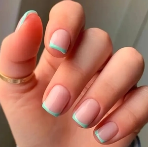 Detail of French tip press-on nails in mint green and nude pink with a square oval shape