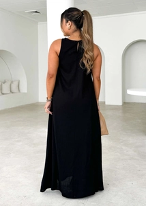 Detailed back view of a minimalist black sleeveless maxi dress with a woven texture finish