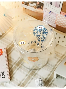 Close-up of a desktop mini trash can with bear sticker and blue heart printed liner
