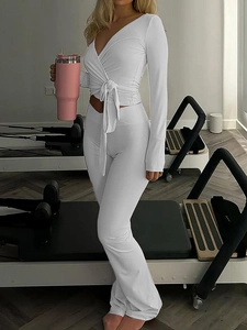 Ensemble de yoga deux pièces blanc avec haut à manches longues col V et pantalon évasé