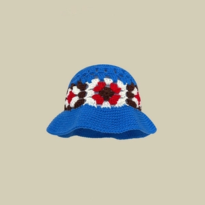 Detaillierte Makroansicht der blauen handgestrickten Häkelmütze mit Blumenmuster