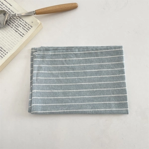 Détail du set de table à rayures bleu clair et blanc en coton-lin avec texture tissée