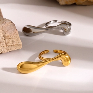 Detail of 18k gold and silver irregular water drop rings on a minimalist stone setting