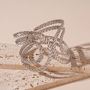 Detailed macro view of silver twisted multi-layer spiral cuff bracelet on stone stand