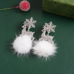 Detail of silver reindeer earrings with snowflake antlers, crystals and white fluffy balls
