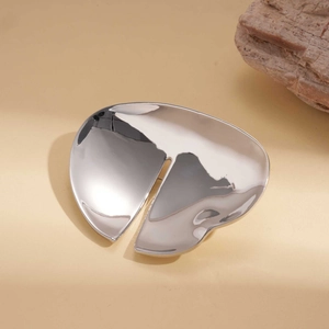 Close-up of polished silver irregular geometric brooch with modern artistic cut-out design