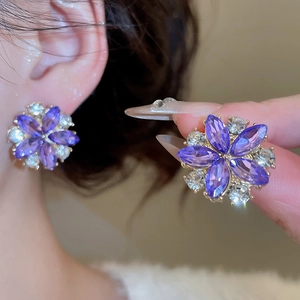 Close-up of elegant purple flower earrings with marquise-cut crystals and white diamonds