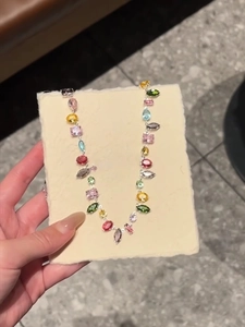 Detail of colorful multi-shape crystal zircon necklace with rainbow gemstones in silver finish