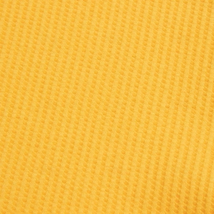 Detailed close-up of yellow waffle knit fabric texture on men's polo shirt