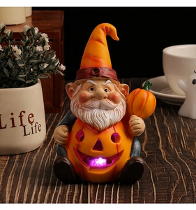 Close-up of a resin garden gnome sitting in a glowing purple pumpkin LED decoration