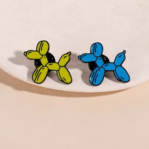 Fashionable balloon dog pins in yellow and blue enamel finish on a beige tray