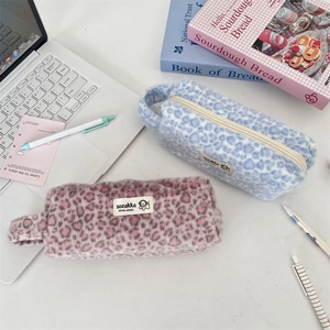 Close-up of plush leopard print makeup pouches with soft faux fur and zip closure