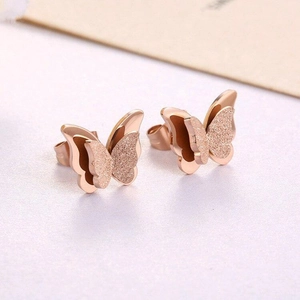 Detailed close-up of rose gold butterfly earrings with dual-texture frosted and polished finish