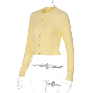Détail du tricot côtelé jaune vif et des boutons métalliques sur le cardigan ajusté