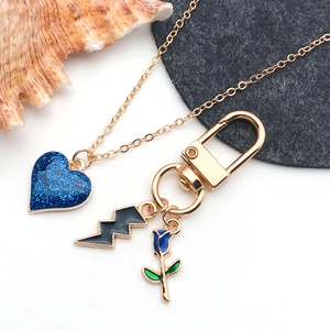 DIY jewelry kit with gold chain, glitter blue heart, lightning, and rose charms
