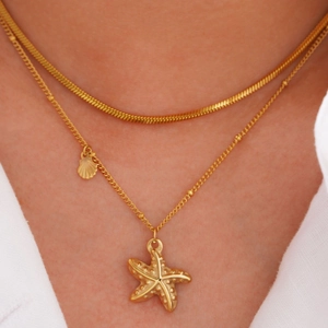 Close-up of layered 14k gold stainless steel necklace with starfish shell charms