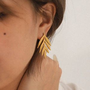 18K gold plated leaf stud earrings for women on model showing minimalist style