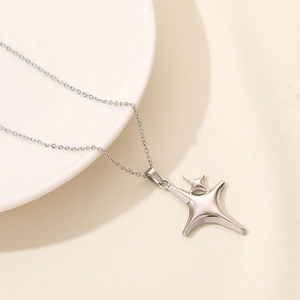 Detail view of a double-layered vintage star pendant on a polished stainless steel chain
