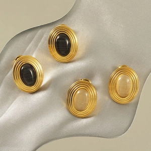 Detailed view of vintage oval stud earrings with black and cream stone in gold setting