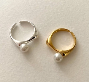 Macro detail of S925 sterling silver stamp on minimalist gold and silver pearl rings
