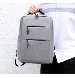 Detail of grey business laptop backpack featuring dual zippers and external USB charging port