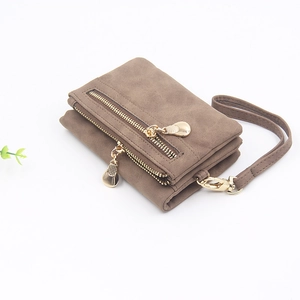 Detail of brown matte faux leather wallet with double gold zippers and a wristlet strap
