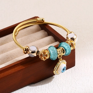 Golden woven rope bangle with evil eye charm, turquoise beads and pavé diamond details