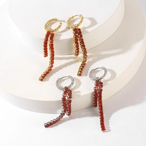 Detail of elegant gold and silver tassel earrings with red rectangular zircon stones