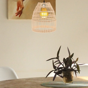 Modern Nordic woven rattan pendant light shade with warm bulb in a dining room setting