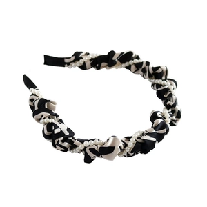 Monochrome paisley fabric headband with elegant white pearl accents on white background