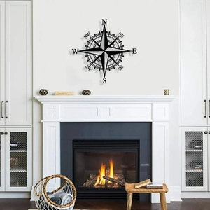 Vintage metal compass wall decor in black finish mounted above a cozy living room fireplace