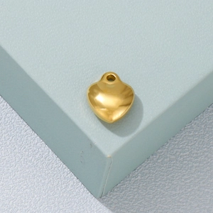 Macro shot of a polished golden heart pendant showing a smooth minimalist finish