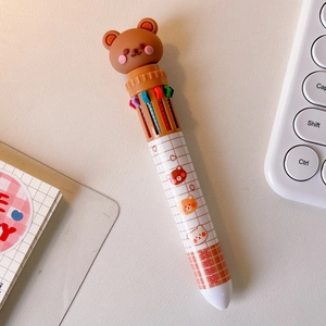 Detail of multi-color retractable ballpoint pen with brown cartoon bear topper and plaid pattern