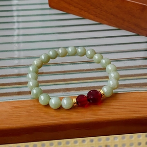 Detail of Nephrite Jade beaded bracelet with red agate accents and golden metal spacers