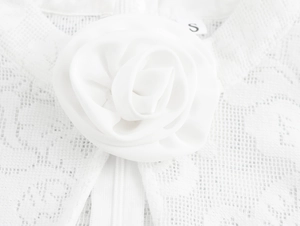 Detail of white lace dress with floral decoration and zipper closure on the back
