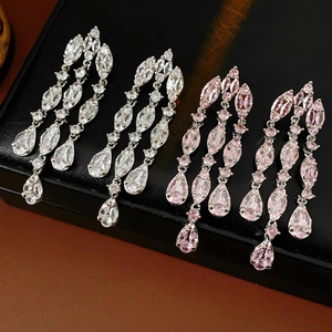 Close-up of silver and pink zircon water drop tassel earrings on black display stand
