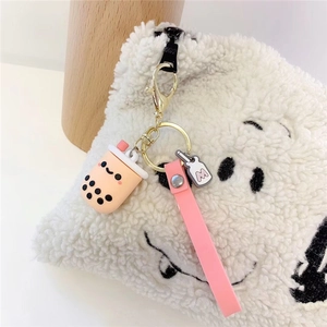 Pink milk tea cup keychain with silicone wrist strap and gold metal clasp on a bag
