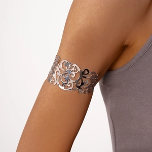 Dettaglio di un bracciale da braccio in argento con motivi floreali e geometrici cavi