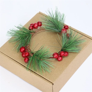 Handgefertigter Weihnachtskranz mit grünen Tannennadeln und roten Glitzerbeeren auf Box