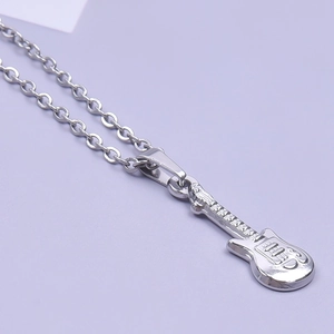 Close-up of a silver stainless steel guitar pendant on an O-chain with high metallic luster